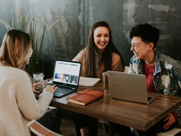 Three students laughing and studying together