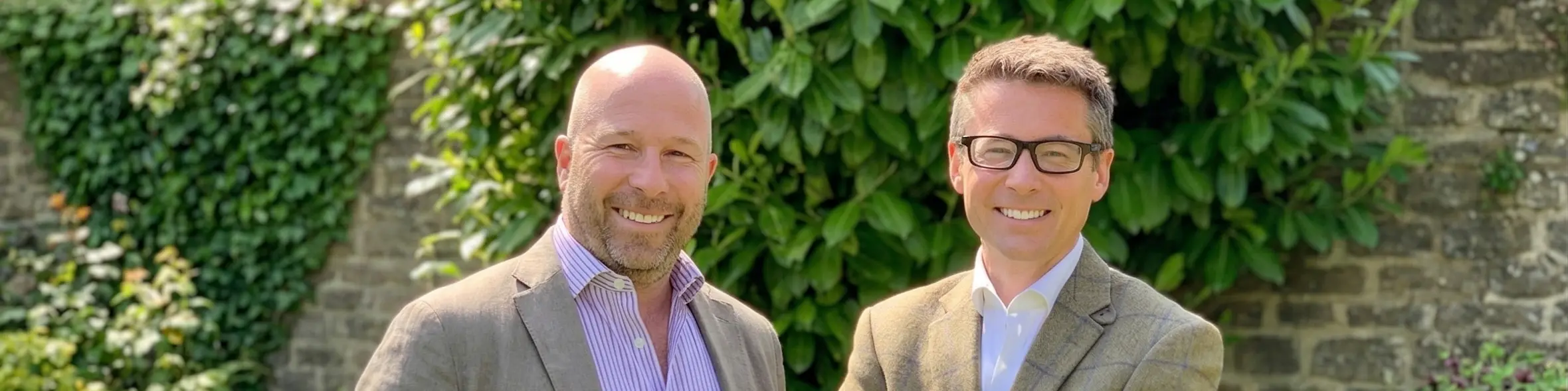 Chris Morling and Simon Andrews, founders of Studee, stand smiling in a garden setting.