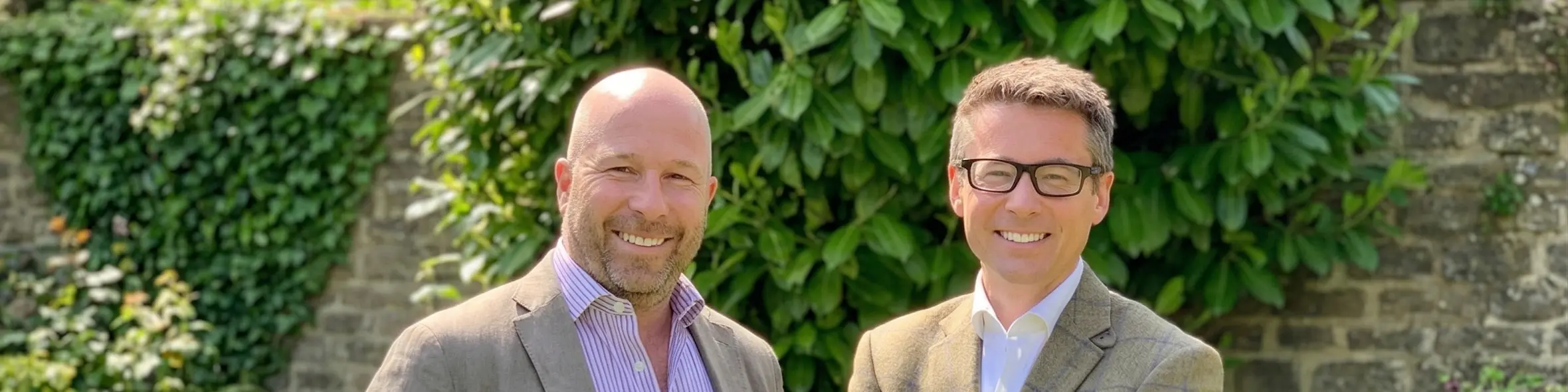 Chris Morling and Simon Andrews, founders of Studee, stand smiling in a garden setting.