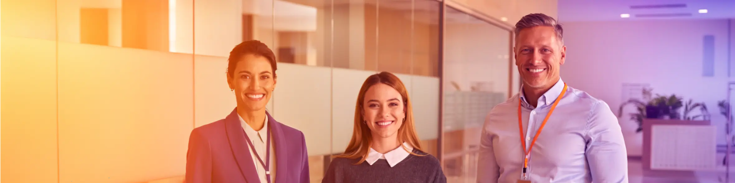 A female school counselor, female student and male university admissions officer stand confidently in a bright university space, representing Studee's mission to simplify international admissions for schools, students, and universities.