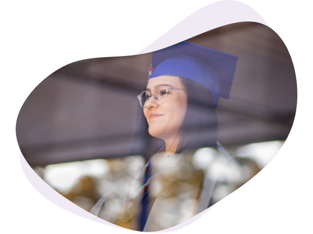 Graduates throwing their hars in the air, wearing a black graduation gown.