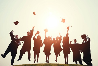 Aerial view of a group of people graduating throwing morter boards into the air