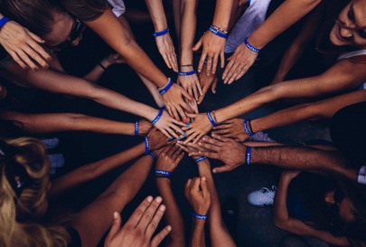 Group of hands all coming together to form a circle.