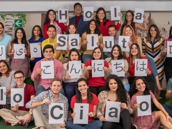 Studee team holding up letters in different languages