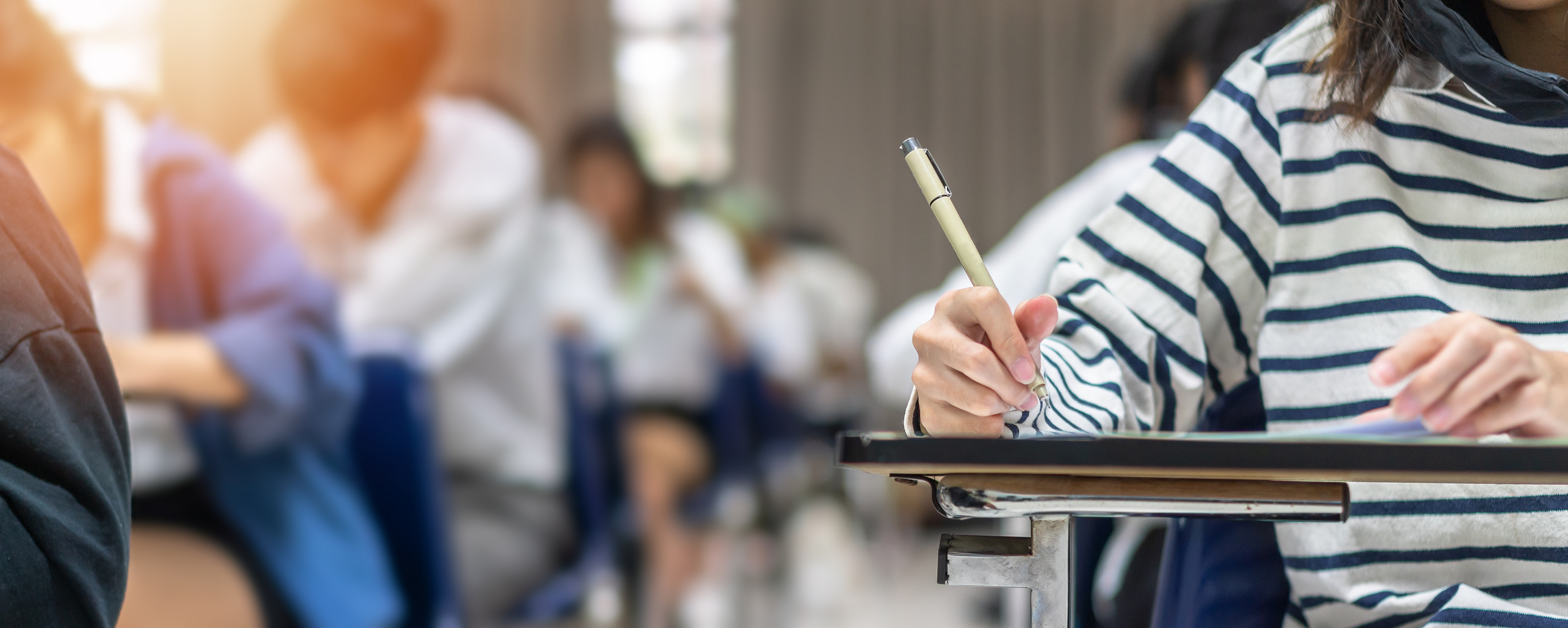Student writing at their desk