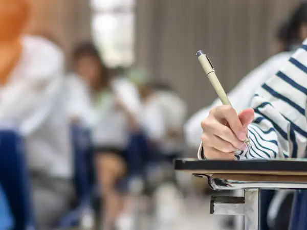 Student writing at their desk